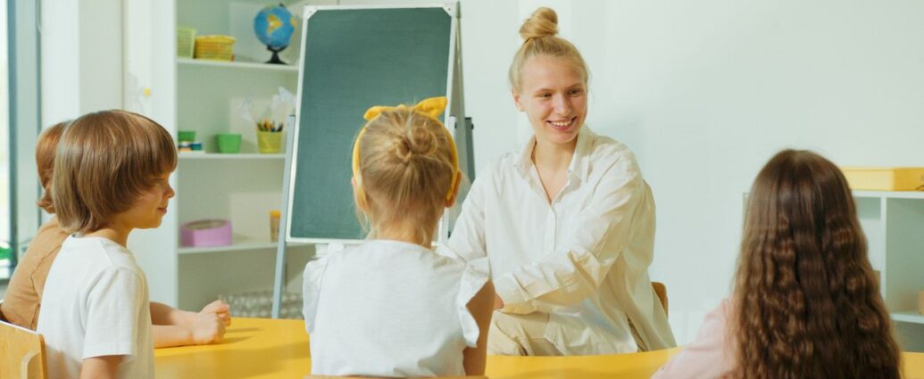 Educatrice con bambini piccoli in un'aula colorata dell'asilo