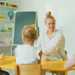 Educatrice con bambini piccoli in un'aula colorata dell'asilo
