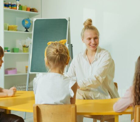 Educatrice con bambini piccoli in un'aula colorata dell'asilo