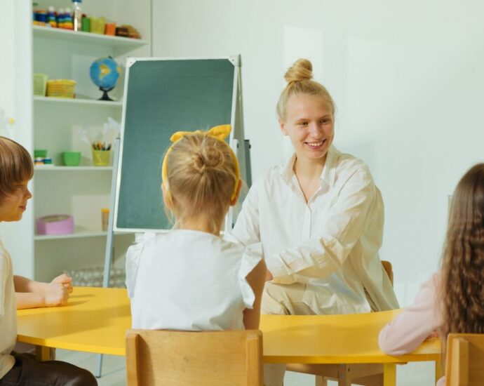 Educatrice con bambini piccoli in un'aula colorata dell'asilo