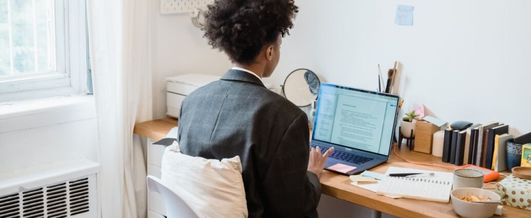 Scrivania ordinata di un home office con persona al lavoro