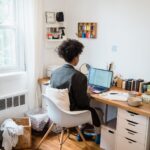 Scrivania ordinata di un home office con persona al lavoro