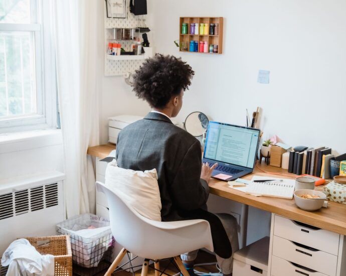Scrivania ordinata di un home office con persona al lavoro