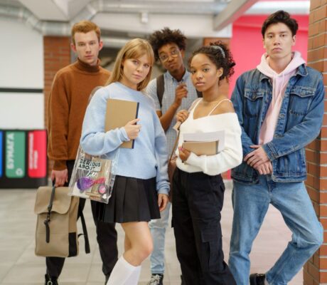 Studenti delle superiori con libri e zaini nel corridoio della scuola