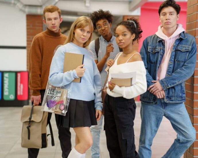 Studenti delle superiori con libri e zaini nel corridoio della scuola