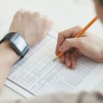 Studente che scrive a matita durante una prova d'esame