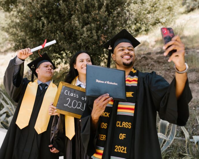 Gruppo di amici con il diploma che si scattano un selfie