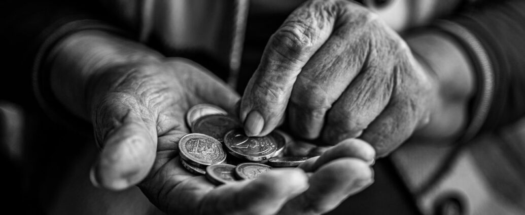 Mani di una persona anziana che contano monete