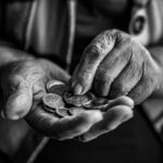 Mani di una persona anziana che contano monete