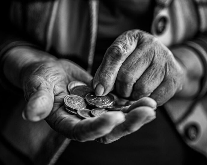 Mani di una persona anziana che contano monete