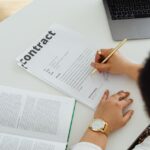 Persona che firma un documento alla scrivania