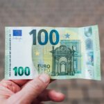 Mano che tiene una banconota da 100 euro
